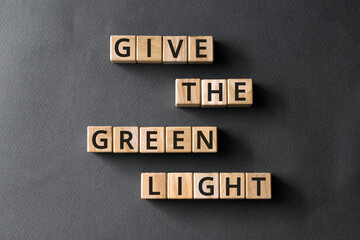 Ggive the green light - phrase from wooden blocks with letters, the go-ahead concept, gray background
