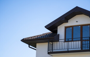 Brown corrugated metal profile roof installed on a modern house. The roof of corrugated sheet. Roofing of metal profile wavy shape. Modern roof made of metal. Metal roofing.