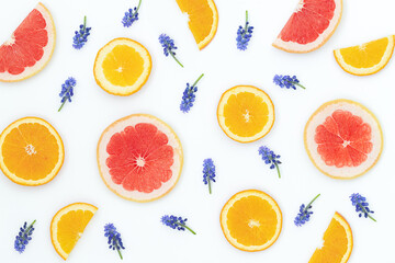 Summer bright background with oranges, grapefruites and blue flowers on the gray surface	