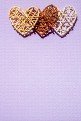 3 braided hearts on a pale purple background
