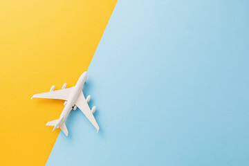 Toy white plane on a colored background, top view