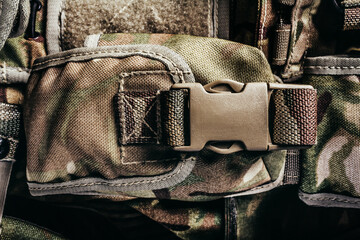Close-up photo of multi camouflaged soldier vest pouch with lock catch.