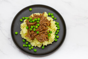 Butterflied beef with mashed potatoe and peas