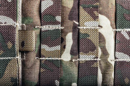 Close-up photo of military camouflaged armored vest molle system.