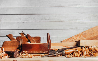 Photo of wooden old fashioned planes with carving chisels laying on workbench table.