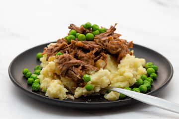 Butterflied beef with mashed potatoe and peas