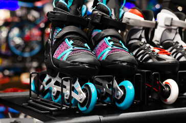 Photo of various colored roller skates standing on sport store shelf.