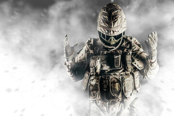 Photo of fully equipped soldier in heavy level 3 amor ammunition standing in white smoke.