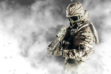 Photo of fully equipped soldier in heavy level 3 amor ammunition and rifle standing in white smoke.