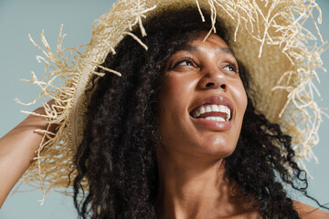 Black woman in straw hat smiling and looking upward