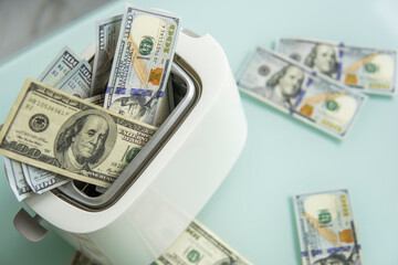 US Hundred dollar bills burning in the toaster. US dollars roasting in toaster. Financial concept.
