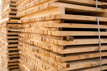 Storage of piles of wooden boards on the sawmill. Boards are stacked in a carpentry shop. Sawing drying and marketing of wood. Pine lumber for furniture production, construction. Lumber Industry.