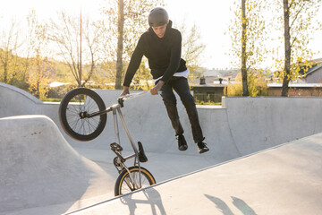 BMX rider makes a TAilwhip trick. Young man doing tricks in the air on a BMX bike. BMX freestyle on...