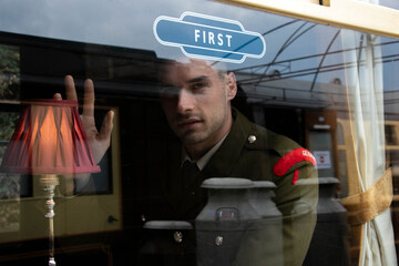 Handsome ww2 male officer in uniform arriving on train as seen through carriage window, waving