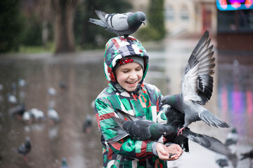 naughty boy and doves in the park in the rain