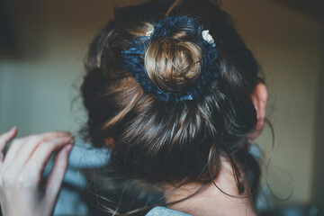 Obraz premium Back view of a comfortly bun hairstyle of a young woman