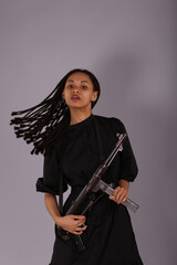 Beautiful woman in black dress with vintage submachine gun
