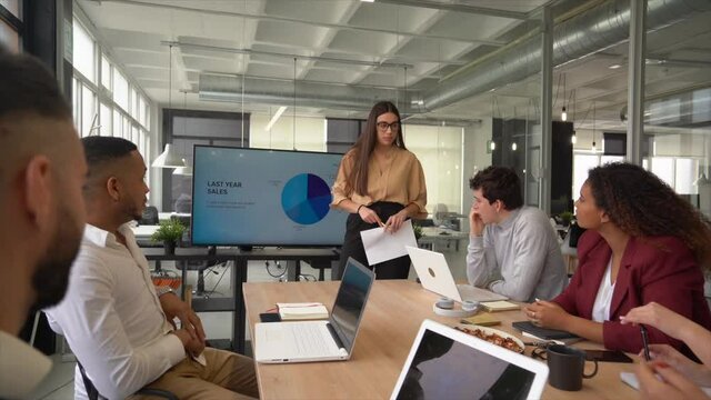Businesswoman discussing with team in meeting at coworking space