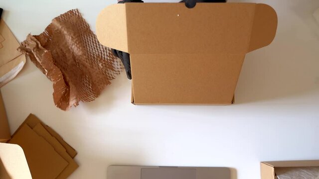 Hands closing box with handmade products for shipment