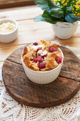 Bread pudding with raspberry. Side view, wooden background.