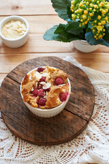 Bread pudding with raspberry. Side view, wooden background.