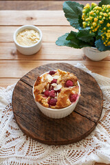 Bread pudding with raspberry. Side view, wooden background.
