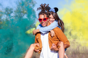 Beautiful young man and woman in light up colored smoke bombs - Happy friends having fun in the...
