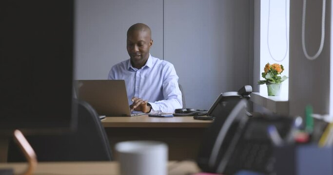 Businessman sitting at desk working on laptop