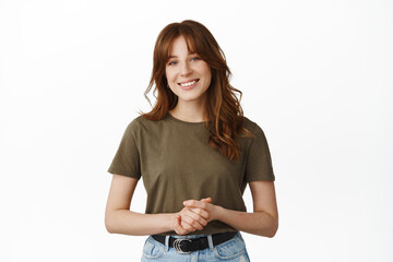 How may I assist you. Smiling friendly woman standing in pleasant formal pose, keeping emotions...