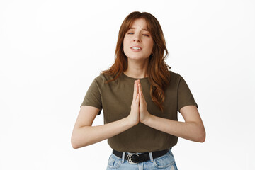 Please help me. Coy girl need something, begging you, pleading and looking hopeful, standing against white background