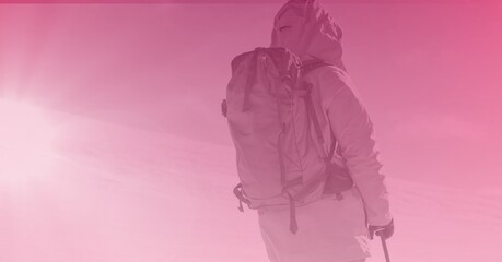 Composition of rear view of skier in mountains with copy space and pink tint
