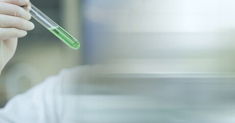 Composition of scientist holding test tube with green liquid and copy space