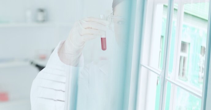 Composition of scientist holding test tube with red liquid working in laboratory and copy space