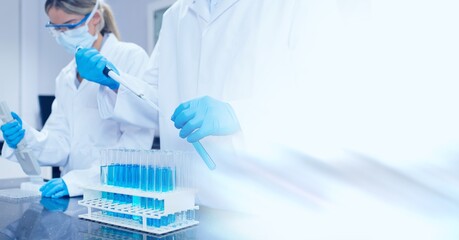 Composition of male and female lab technicians at work, with blurred copy space to right