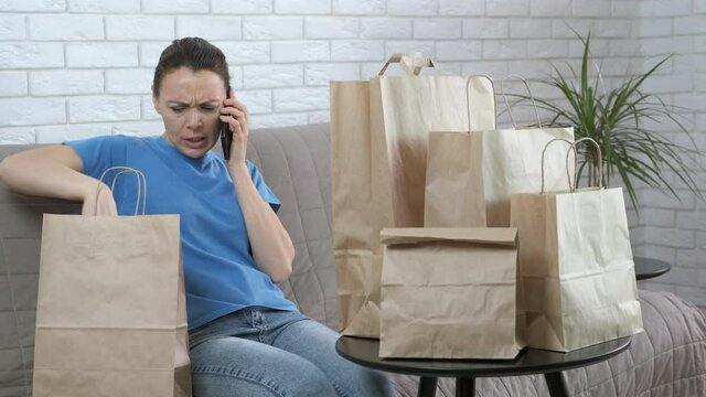 Drop shipping. A businesswoman sits in the room by eco craft bags and speak on telephone in the room.