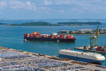 Busy container terminal with car carrier and container ship.