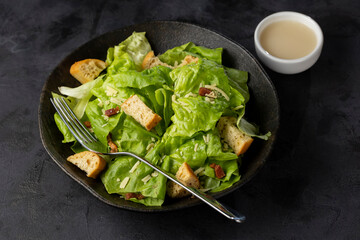 Caesar salad with croutons and bacon.