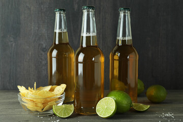 Beer bottles and snacks against dark wooden background