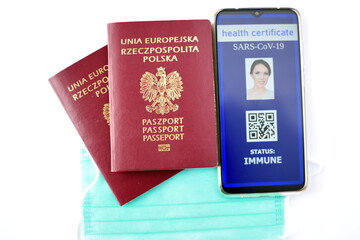 Fototapeta na wymiar Traveling during SARS-CoV-19 pandemic. Traditional passport and Covid-19 passport application in mobile phone.