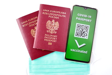 Fototapeta na wymiar Traveling during SARS-CoV-19 pandemic. Traditional passport and Covid-19 passport application in mobile phone.