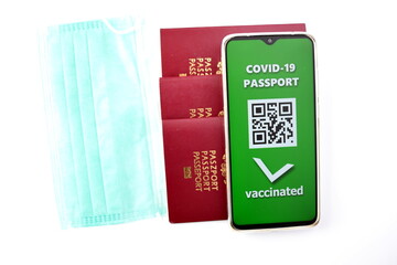 Traveling during SARS-CoV-19 pandemic. Traditional passport and Covid-19 passport application in mobile phone.