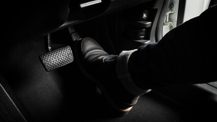 Foot pressing foot pedal of a car to drive. Accelerator and brake pedal in a car. Driver driving...