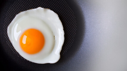 Top view of, Fried egg and Fresh yolk yellow uncooked in pan background with copy space, Preparation food or Breakfast with non stick kitchenware and oil free for Healthy food and Health care concept.