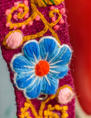 Fototapeta na wymiar Peruvian crafts: Embroidered flower ornaments on a handmade fabric