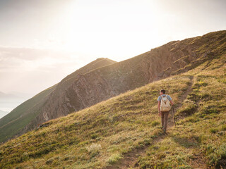 Young man travels alone on the backdrop of the mountains