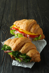 Tasty croissant sandwiches on wooden background, close up