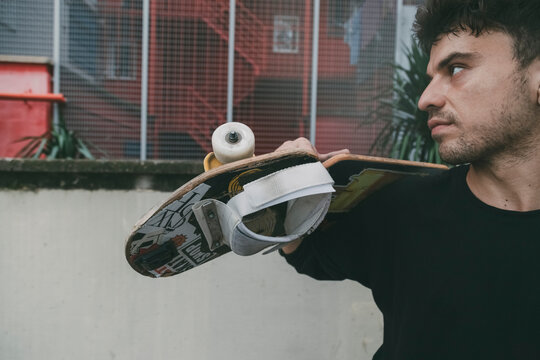 boy resting holding a snakeboard with urban and copyspace background