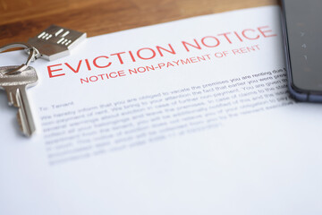 Document on eviction from housing for non-payment lies on table with keys