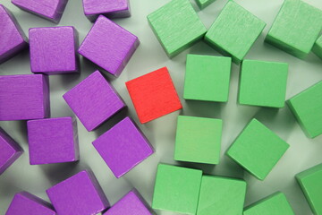 the concept of green and purple wooden cubes with one red cube in the middle