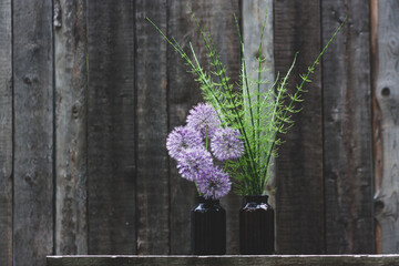 Bouquets of allium and horsetail on wooden background.